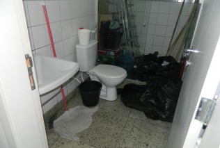 Lixo e material de limpeza acumulados no banheiro da Setop.